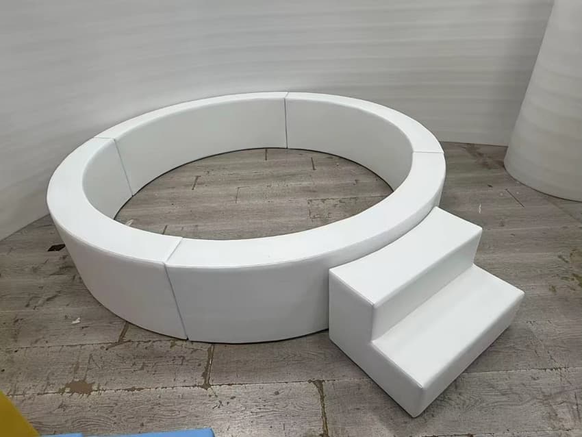 Round white ball pit with a two-step entry stair