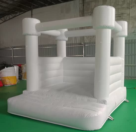 All-white inflatable bounce house with rounded pillar corners, seen from the front corner